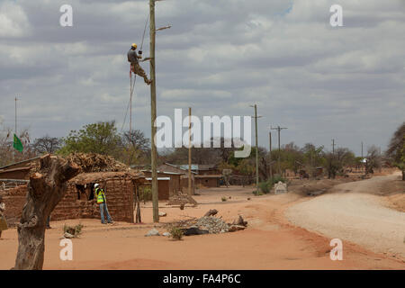 Arbeitnehmer eine Zeichenfolge neue Stromkabel in einem ländlichen Dorf in der Nähe von Dodoma, Tansania, Ostafrika. Stockfoto