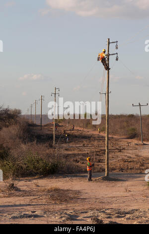 Arbeitnehmer eine Zeichenfolge neue Stromkabel in einem ländlichen Dorf in der Nähe von Dodoma, Tansania, Ostafrika. Stockfoto