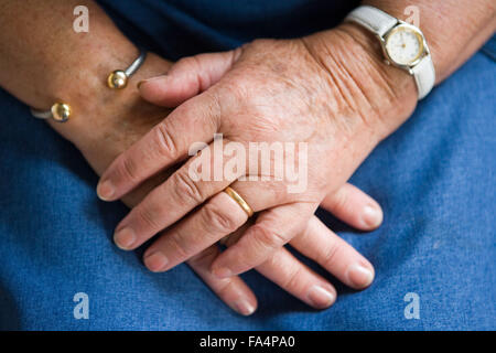 Ältere Menschen mit den Händen auf dem Schoß, Stockfoto