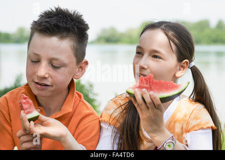 Kinder freuen sich über Scheiben Wassermelone bei Picknick, München, Bayern, Deutschland Stockfoto