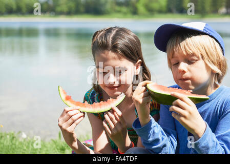 Kinder freuen sich über Scheiben Wassermelone bei Picknick, München, Bayern, Deutschland Stockfoto