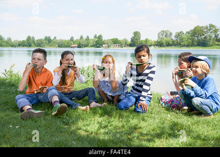 Kinder freuen sich über Scheiben Wassermelone bei Picknick, München, Bayern, Deutschland Stockfoto