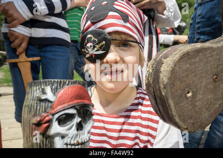 Portrait eines jungen verkleidet als Pirat auf einem Piratenschiff mit seinen Freunden stehen hinter ihm, Bayern, Deutschland Stockfoto