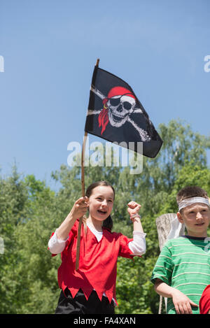 Mädchen hält Piratenflagge mit ihrer Freundin in Abenteuer Spielplatz, Bayern, Deutschland Stockfoto