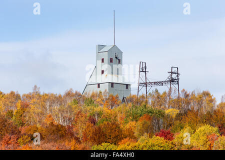 Verlassene Mine Welle Haus und andere industrielle Struktur auf einem Hügel und hinter einer Baumgruppe in brillanten Farben des Herbstes. Stockfoto