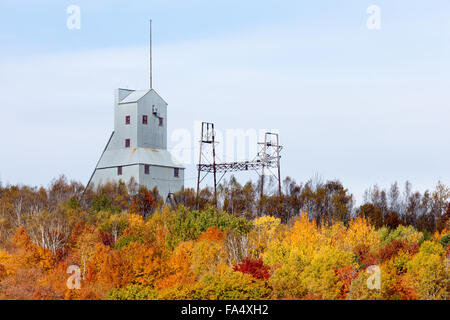 Verlassene Mine Welle Haus und andere industrielle Struktur auf einem Hügel und hinter einer Baumgruppe in brillanten Farben des Herbstes. Stockfoto