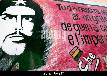 Eine Schule in Luribay, Bolivien, Südamerika mit Che Guevara Hand lackiert in Schwarz gegen einen roten Rahmen auf der Seite der weißen Wand, Stockfoto