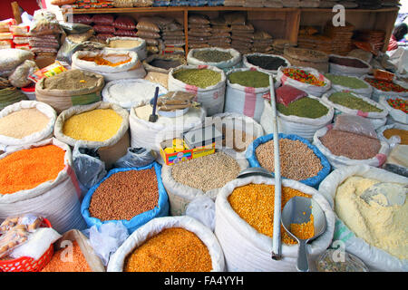 Taschen von Grundnahrungsmitteln in einem Freiluftmarkt in Kampala, Uganda.  Zu sehen sind Bohnen, aber, Getreide, Mais, Gewürze, Teigwaren, Zucker, Reis. Stockfoto
