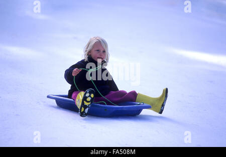 Kinder, Winter, Rodeln in Schneefelder, junges Mädchen über 6 Jahre alt Rodeln. Stockfoto