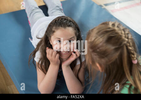 Mädchen liegend Gymnastikmatte Sport Hall, Bayern, München, Deutschland Stockfoto