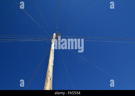 Elektrische Leitungen und Telefonleitungen angeschlossen an Pylon, Uyuni, Bolivien Stockfoto