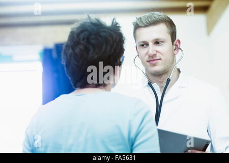 Ältere Patienten im Gespräch mit jungen Arzt in einem Krankenhaus, Freiburg Im Breisgau, Baden-Württemberg, Deutschland Stockfoto