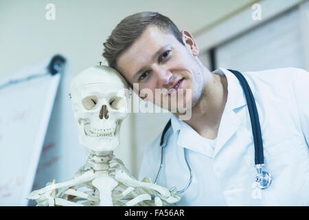 Porträt eines jungen Arztes mit Skelett in Arztpraxis, Freiburg Im Breisgau, Baden-Württemberg, Deutschland Stockfoto