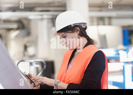 Ingenieurin mit einem Smartphone in einer Industrieanlage, Freiburg Im Breisgau, Baden-Württemberg, Deutschland Stockfoto