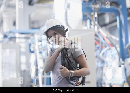 Weiblichen Techniker tragen Spule Seil auf Schulter in einer Industrieanlage, Freiburg Im Breisgau, Baden-Württemberg, Deutschland Stockfoto