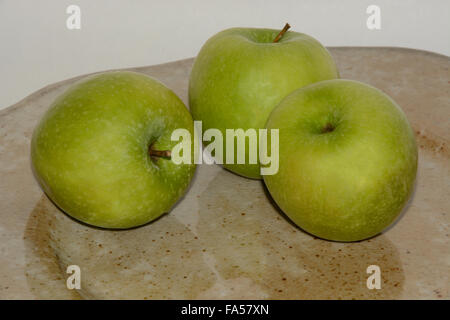 Drei grüne Granny Smith Äpfel auf handgefertigte Keramik-Platte Stockfoto