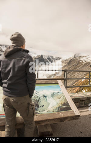 Reifer Mann Vergleich der schmelzenden Grossglockner Gletscher und Stream mit einem früheren Bild in einer Vitrine, Kärnten, Österreich Stockfoto