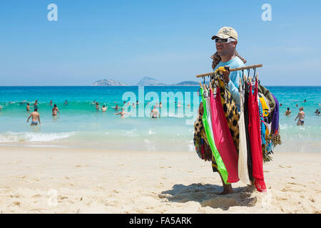 RIO DE JANEIRO, Brasilien - 15. März 2015: Ein Strand Anbieter verkaufen bunten Kanga Sarongs trägt Ware in Ipanema. Stockfoto