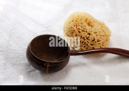 Draufsicht der Spongeand Kokosnussschale mit Griff auf Handtuch Stockfoto