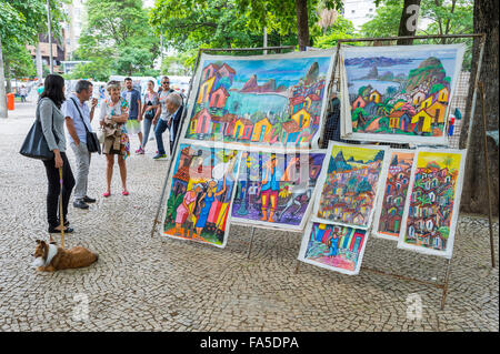 RIO DE JANEIRO, Brasilien - 25. Oktober 2015: Shopper betrachten Kunst auf dem Outdoor-Messe Hippie Markt in Ipanema angezeigt. Stockfoto