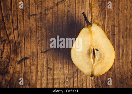Gelbe Birne in Scheiben geschnitten auf rustikalen Holztisch, Retro-getönten, Top Aussicht mit Textfreiraum Stockfoto