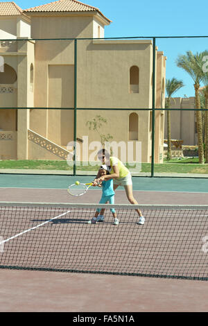 Mädchen und Mutter Tennis spielen Stockfoto