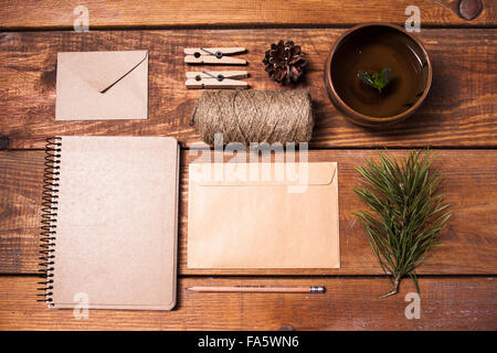 Notizbuch für Rezepte, Papier Envelopess, Seil und Wäscheklammern auf Holztisch. Stockfoto