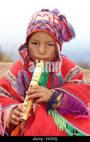 Peruanische Boy In traditioneller Kleidung spielt eine Holzflöte Stockfoto