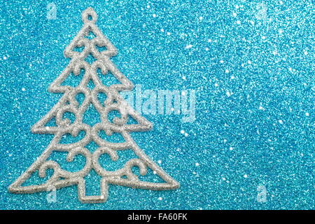 Silber Weihnachten Baumschmuck auf blau glänzenden Hintergrund mit kleinen Schneeflocken Stockfoto