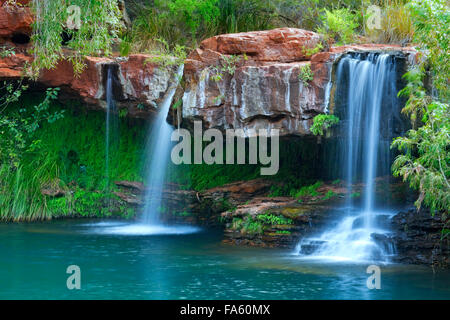 Ein kleiner Wasserfall fließt in die Fern-Pool im Karijini National Park, Western Australia. Stockfoto