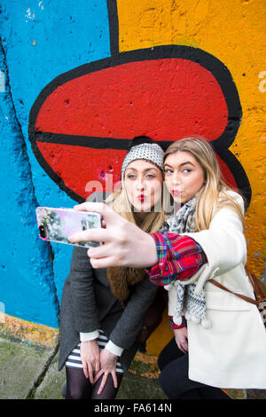 Mädchen nehmen eine Selfie am Teil der Berliner Mauer Deutschland Stockfoto