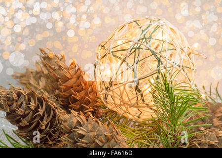 Selbstgemachte Weihnachtsdekoration mit Glühbirnen und Tannenzapfen Stockfoto