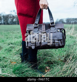 Frau im roten Mantel hält eine Mulberry Roxanne Lederhandtasche Stockfoto