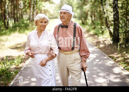 Älteres Ehepaar im Smart Casual-Wear zu Fuß im Sommerpark Stockfoto