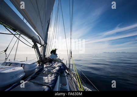 Segler des Bogens Segelboot Eisbergen Ausschau zu halten off Ostküste Grönlands Stockfoto