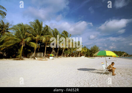 Asiatische Touristen mit Regenschirm in Cenang Beach, der Insel Langkawi, Kedah, Malaysia. Stockfoto