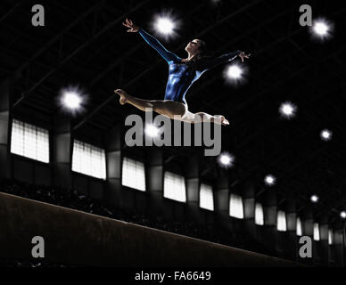 Ein weiblicher Gymnast, eine junge Frau, die Durchführung einer Stock-Routine, in der Luft mit Beinen und Armen ausgestreckt und zurück gebogen. Stockfoto
