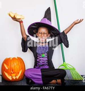 Mädchen in Hexenkostüm mit Kürbis zu Halloween Stockfoto