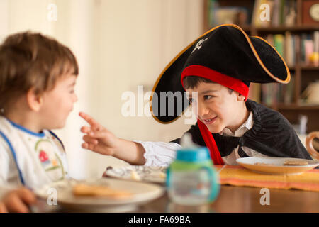 Junge gekleidet im Piratenkostüm mit Kleinkind Bruder spielen Stockfoto