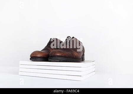 Paar Schuhe auf einen Haufen von Zeitschriften Stockfoto