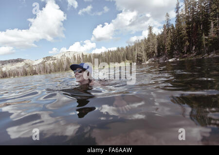 Frau im Bergsee schwimmen, Wyoming, USA Stockfoto