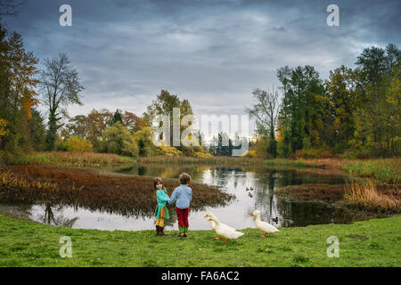 Mädchen und jungen, die See mit drei Enten stehen Stockfoto Mädchen und jungen, die See mit drei Enten stehen Stockfoto