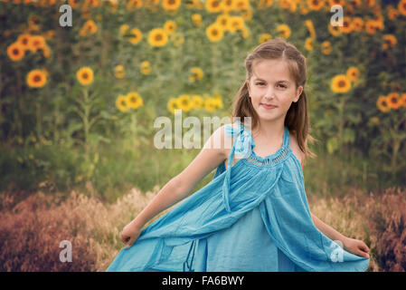 Mädchen in einem Sonnenblumenfeld, drehte sich um Stockfoto