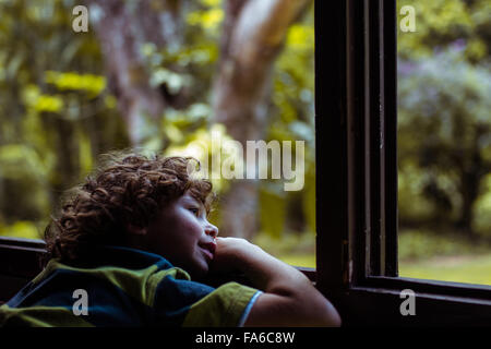 Seitenansicht eines jungen Blick aus dem Fenster Stockfoto