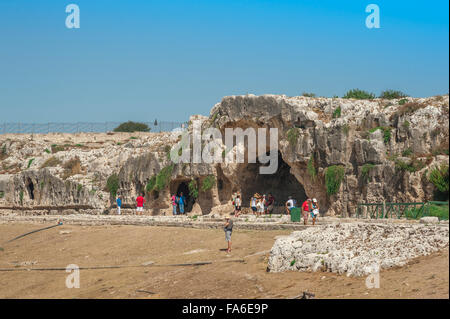 Syrakus Höhle Sizilien, Ansicht von Touristen besuchen die historische "Nymphe Brunnen" (Grotta del Ninfeo) im Archäologischen Park in Syrakus, Sizilien. Stockfoto