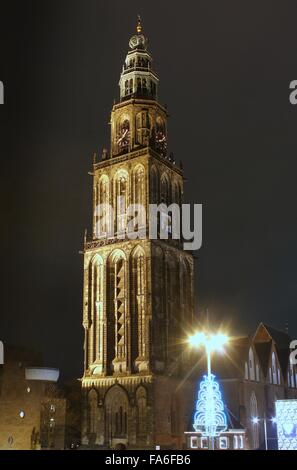 96m hohe Martiniturm (Martinitoren) auf dem zentralen Platz (Grote Markt) in Groningen in den Niederlanden in der Nacht, durch Flutlicht beleuchtet Stockfoto