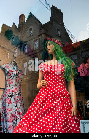 Mannequin mit grünen Haaren, gekleidet in einen roten gepunkteten Kleid in einem Schaufenster in Cockburn Street, Edinburgh, Schottland, UK Stockfoto