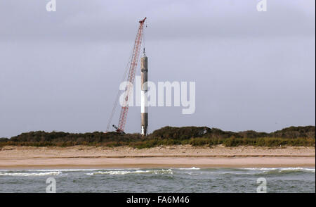 Cape Canaveral, Florida, USA. 22. Dezember 2015. Ein Kran ist gesehen heben die erste Stufe einer SpaceX Falcon 9 Rakete am Morgen, nachdem es 11 ORBCOMM-Kommunikations-Satelliten in die Erdumlaufbahn gestartet, vor der Landung erfolgreich zurück auf Cape Canaveral Air Force Station etwa zehn Minuten später 21. Dezember 2015. Dies ist das erste Mal, das SpaceX eines seiner Raketen an Land gelandet ist. Die historische Leistung stellt einen bedeutenden Schritt in der Technologie der wiederverwendbaren Raketen. Bildnachweis: Paul Hennessy/Alamy Live-Nachrichten Stockfoto