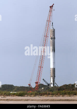 Cape Canaveral, Florida, USA. 22. Dezember 2015. Ein Kran ist gesehen heben die erste Stufe einer SpaceX Falcon 9 Rakete am Morgen, nachdem es 11 ORBCOMM-Kommunikations-Satelliten in die Erdumlaufbahn gestartet, vor der Landung erfolgreich zurück auf Cape Canaveral Air Force Station etwa zehn Minuten später 21. Dezember 2015. Dies ist das erste Mal, das SpaceX eines seiner Raketen an Land gelandet ist. Die historische Leistung stellt einen bedeutenden Schritt in der Technologie der wiederverwendbaren Raketen. Bildnachweis: Paul Hennessy/Alamy Live-Nachrichten Stockfoto