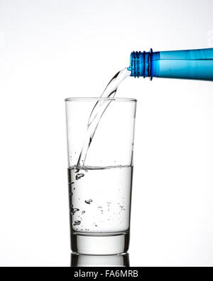 Mineralwasser wird in Glas gegossen Stockfoto